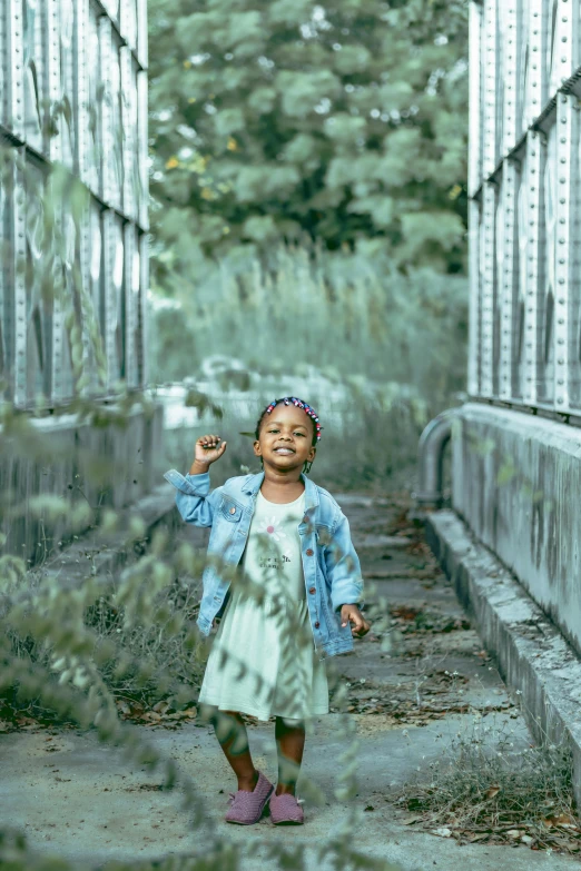 a girl wearing a jacket walking down an alleyway