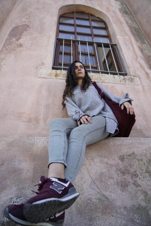 a woman sitting on a ledge with her feet propped up