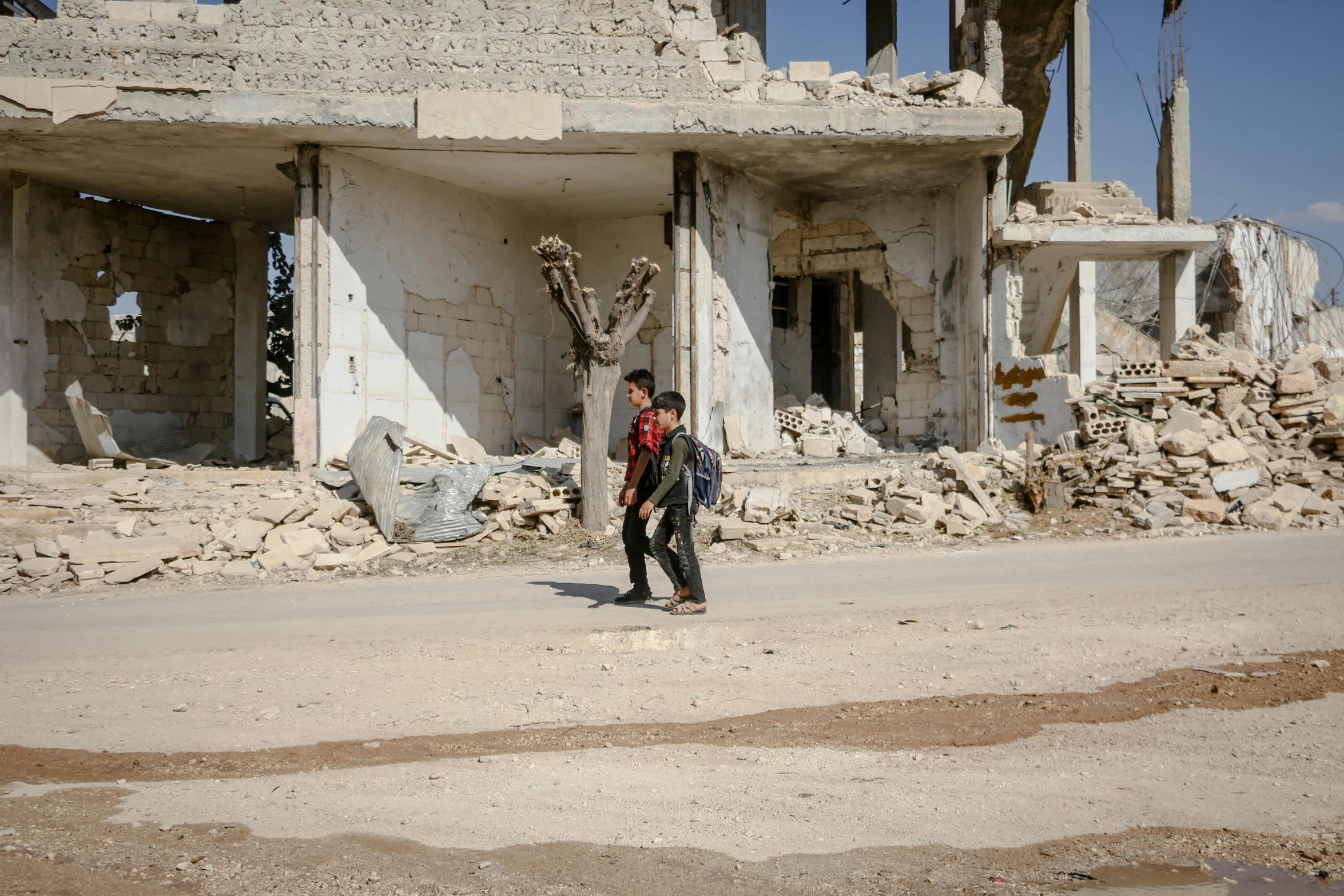 a boy walks past a building with two windows