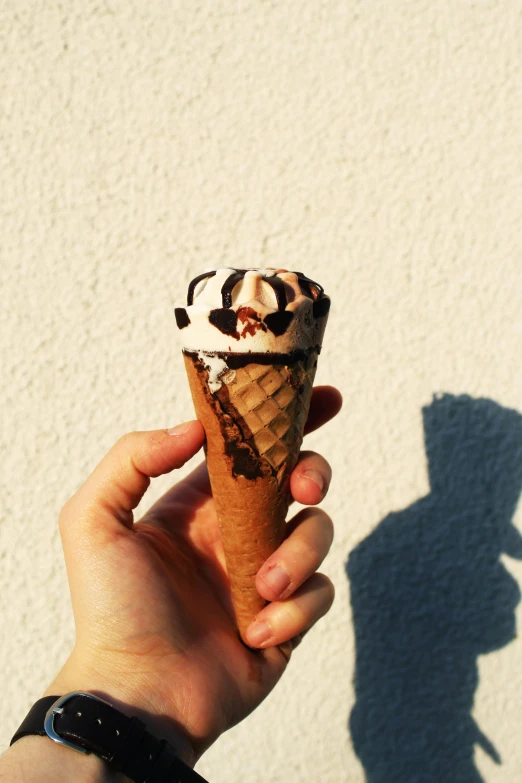 a hand is holding a small scoop of ice cream