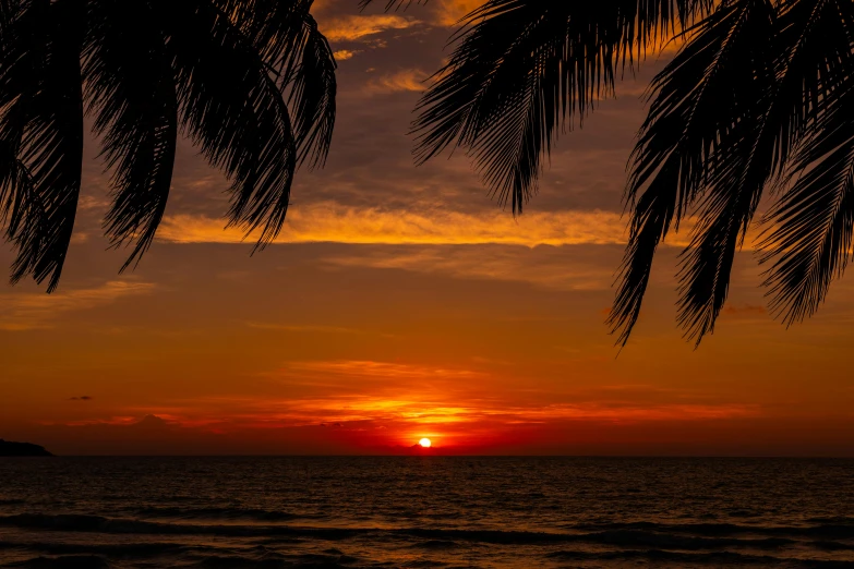 a red and yellow sunset from the ocean