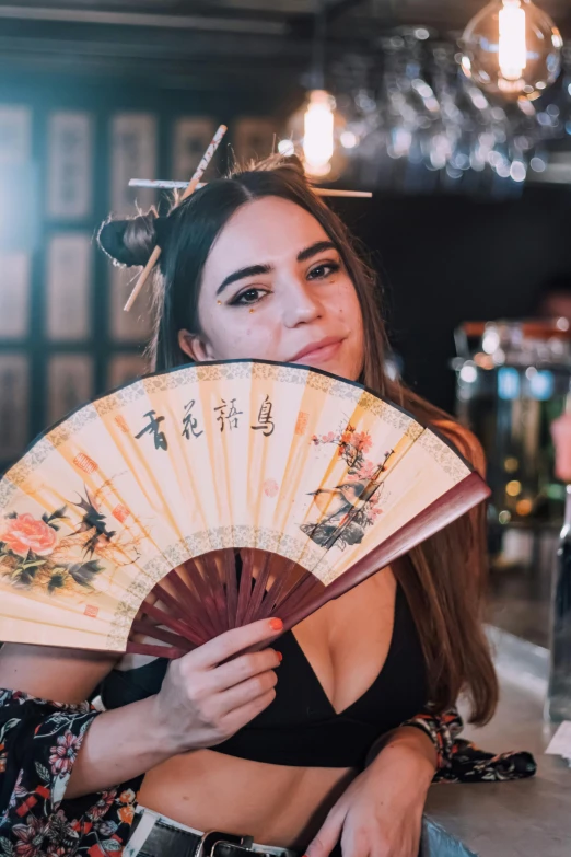 a woman with a fan posing for a po