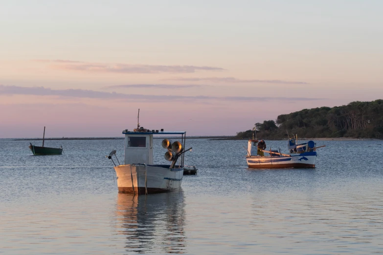 several small boats sailing in calm waters