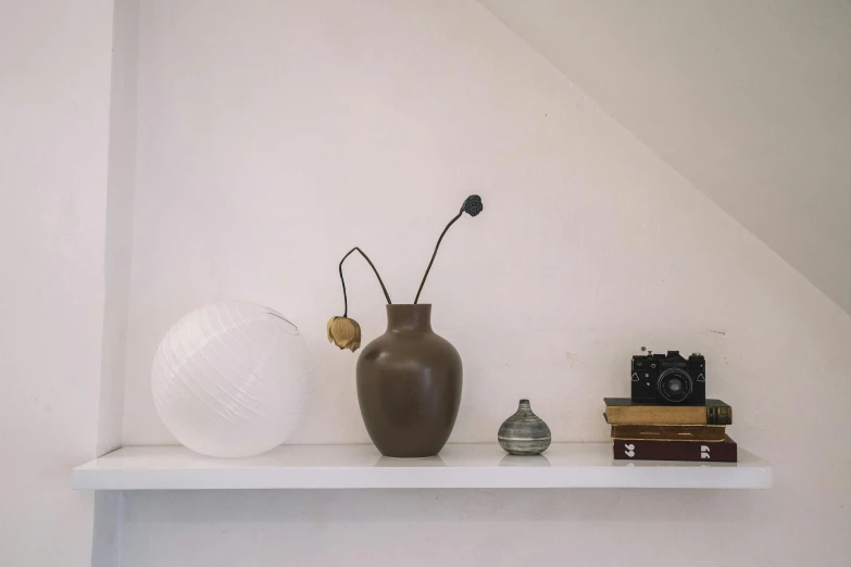 a shelf holds two vases, a white globe, and two books
