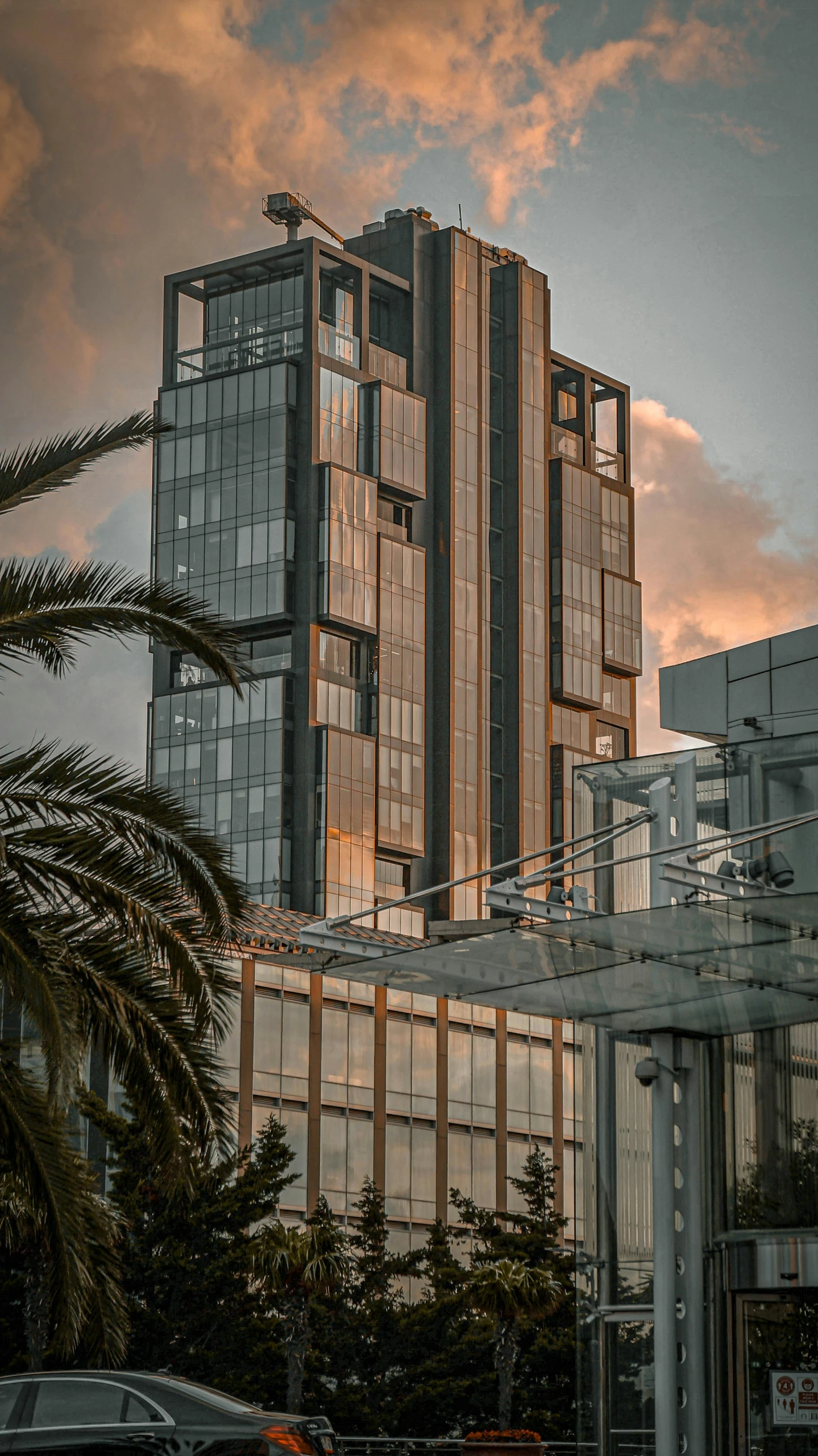 large glass buildings are against the orange sunset