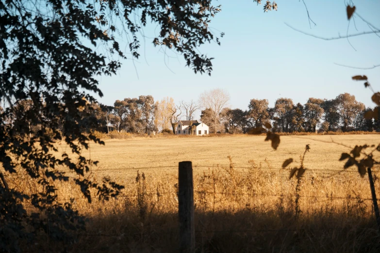 a lone white house stands in the middle of a field