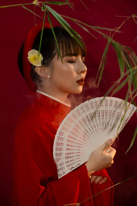 a woman in a red outfit has a fan