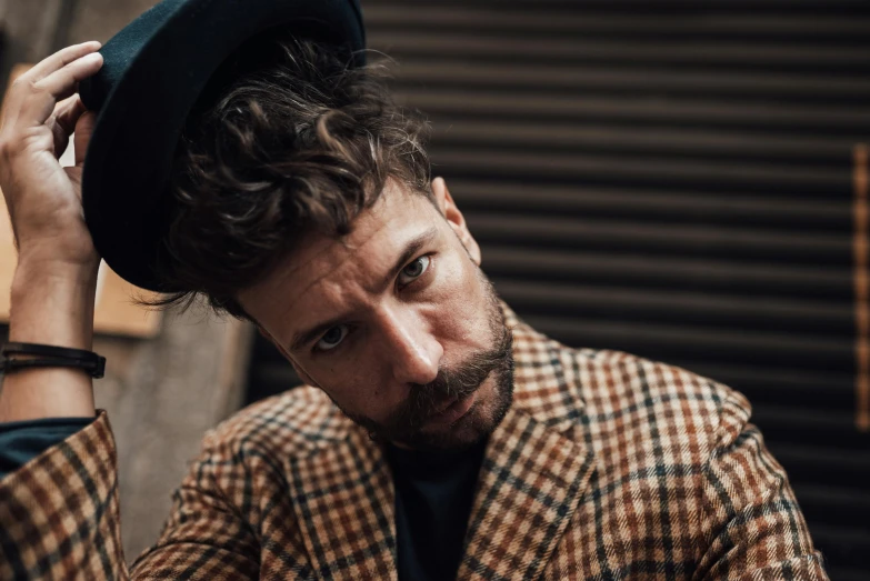 man in brown and black checkered suit and fedora