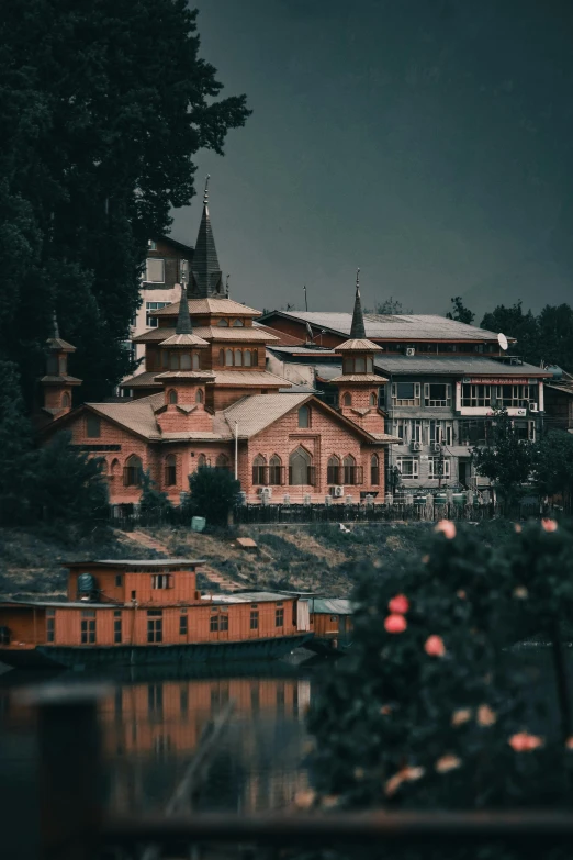 a building sits on top of a mountain by some water