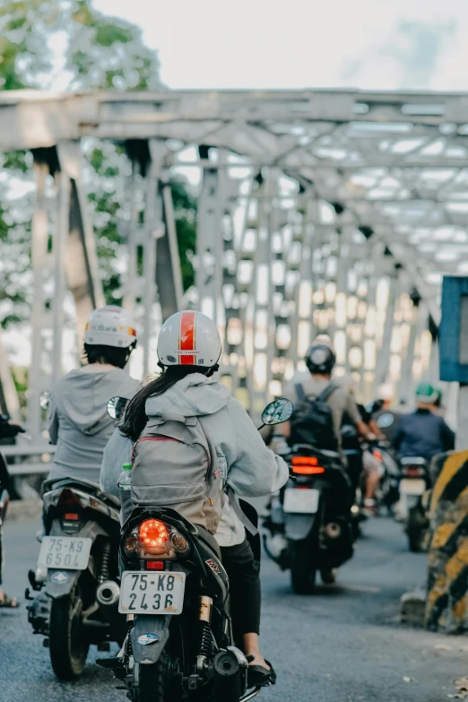 the motorcycle riders are traveling on the road