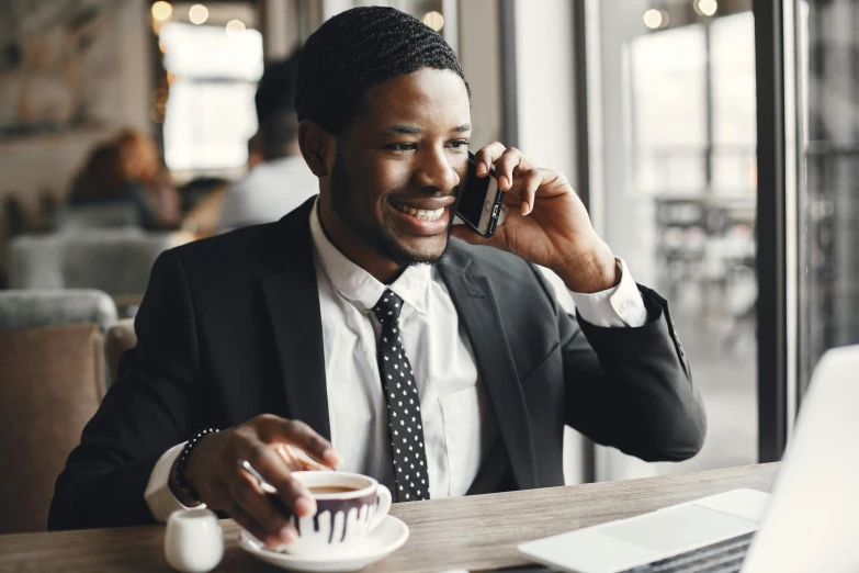 a man is talking on his phone while drinking coffee