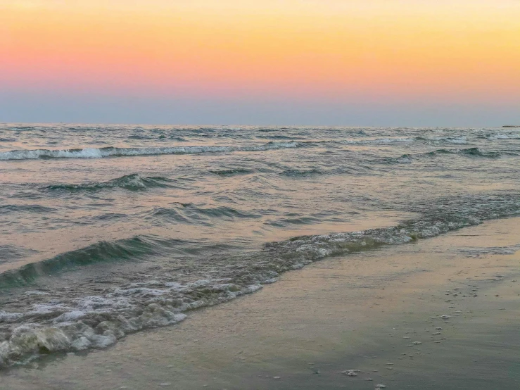 a sunset over the ocean and a small boat