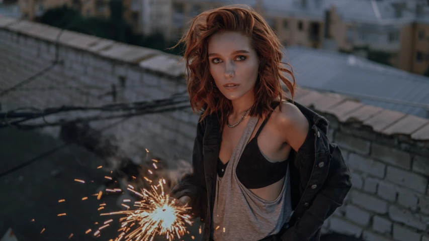 an attractive woman is holding a sparkler