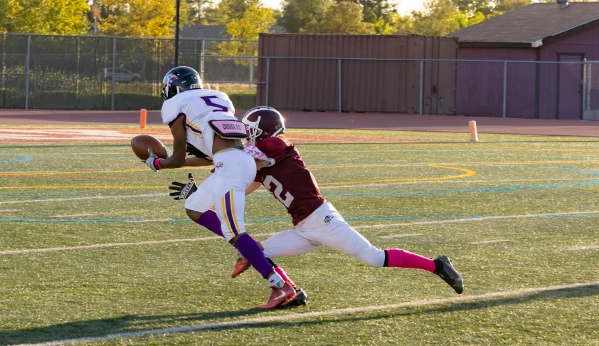 a football player running toward another player on the field