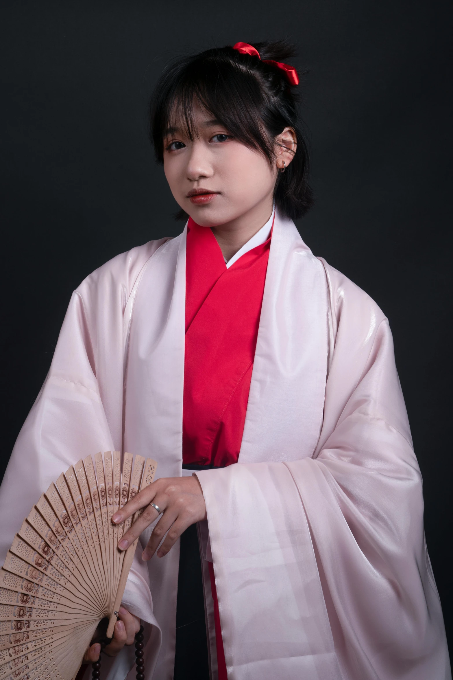 a young asian woman in kimono with fan