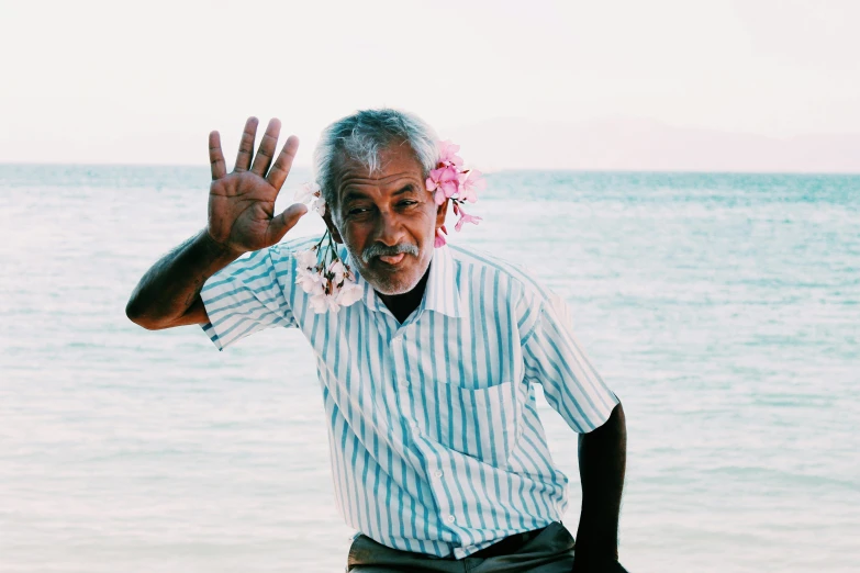 a man on the beach waving at the ocean