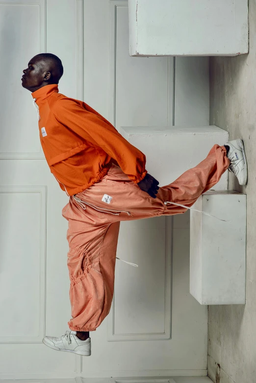 a man stretching on a countertop with his foot propped against a wall