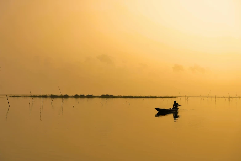 a person sitting in a small boat in the water