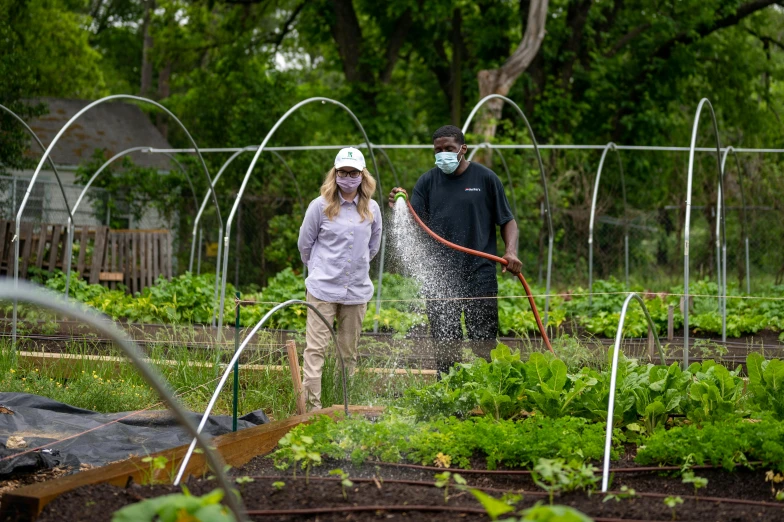 two people in a garden with water spraying out their mouths