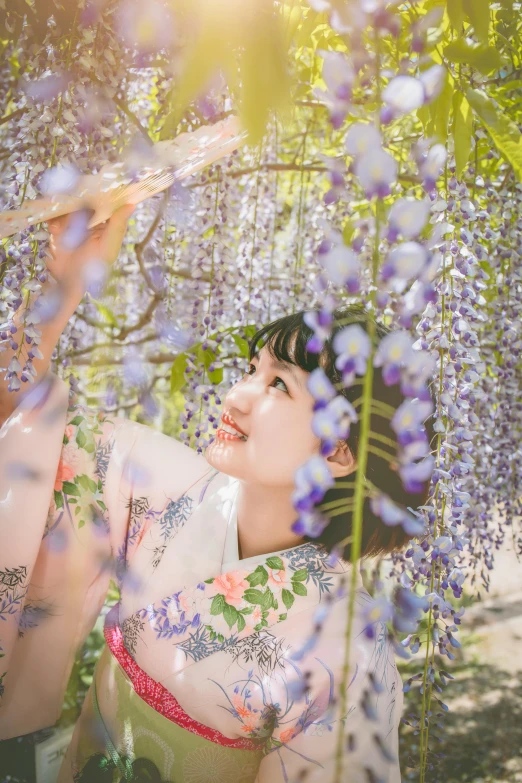 young woman under tree in full bloom attire in outdoor setting