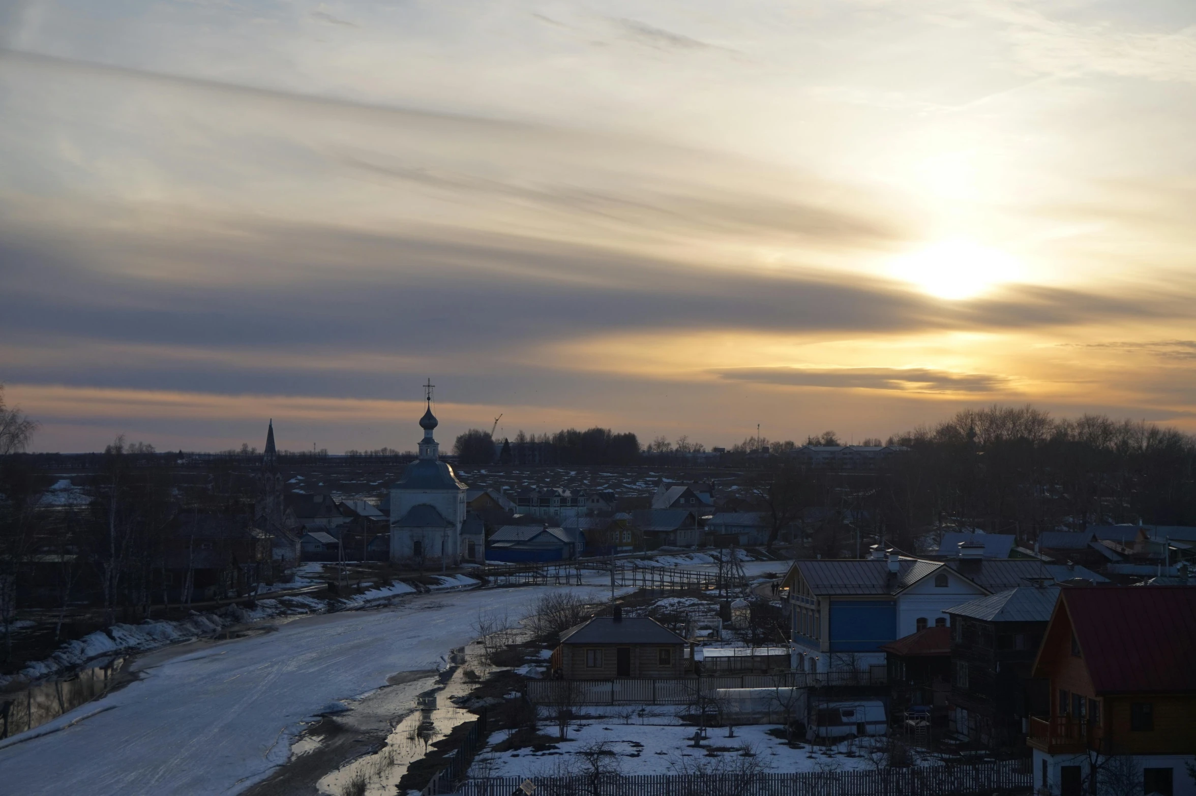 an urban setting with snow, houses and a church