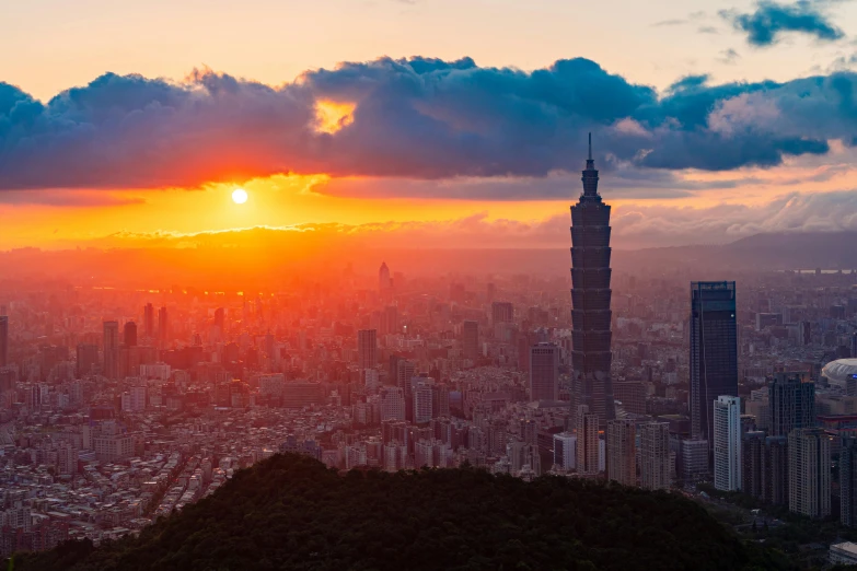 the sun is setting above a city in the mountains