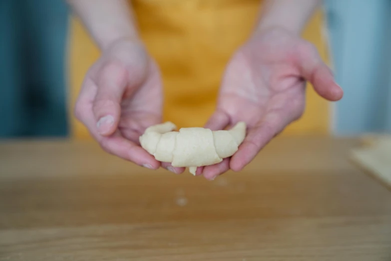 a person holding soing in their hands while sitting on the table