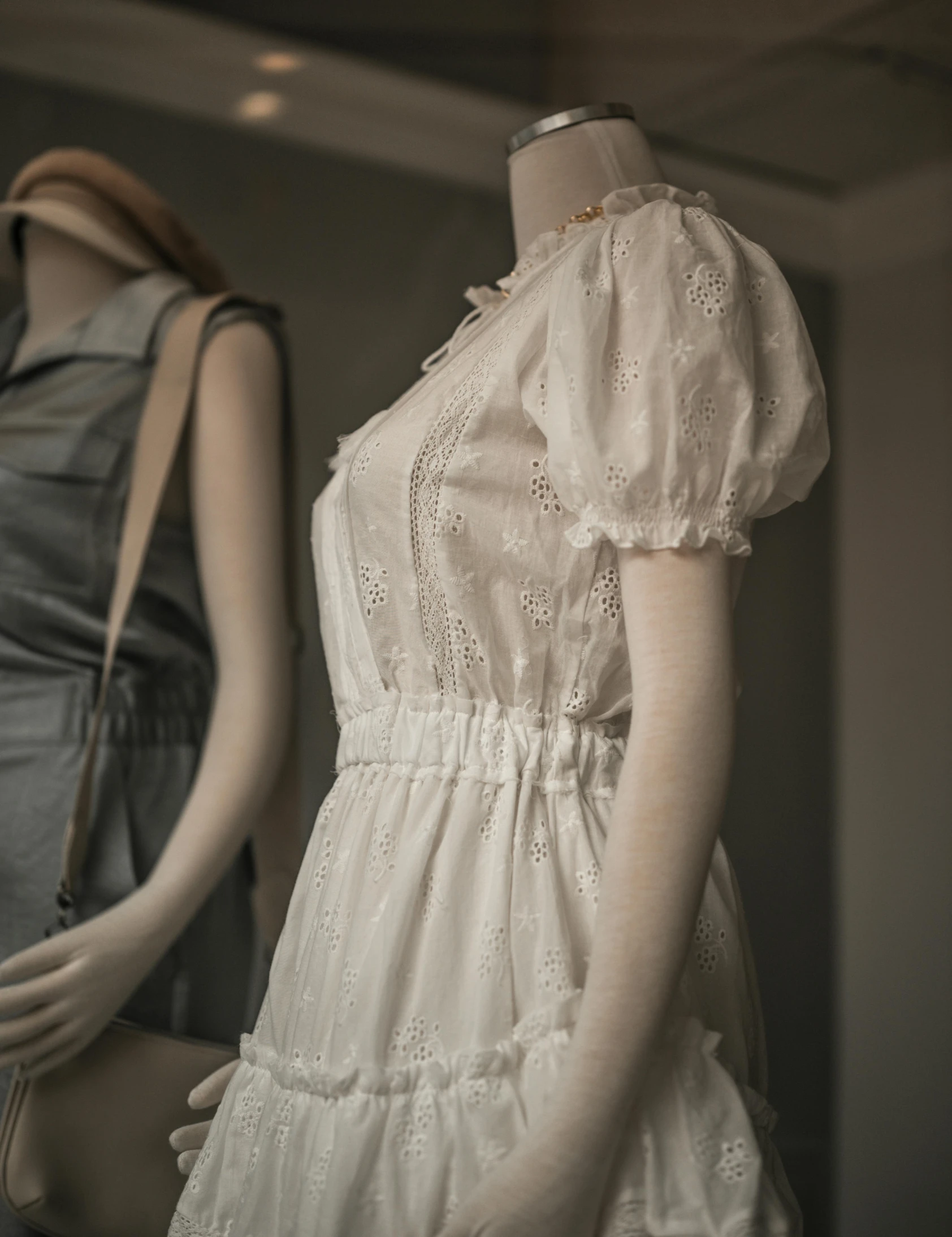 two white dresses and one blue one on display