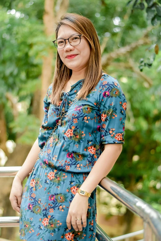 a woman wearing a dress standing next to a railing