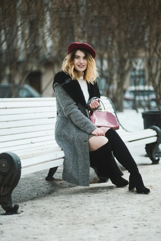 the woman is sitting on the park bench posing for the camera