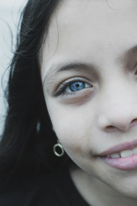 an adorable little girl with blue eyes posing for a po