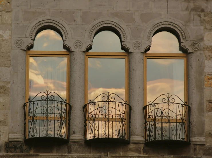 an elegantly decorated iron balcony reflects into the windows