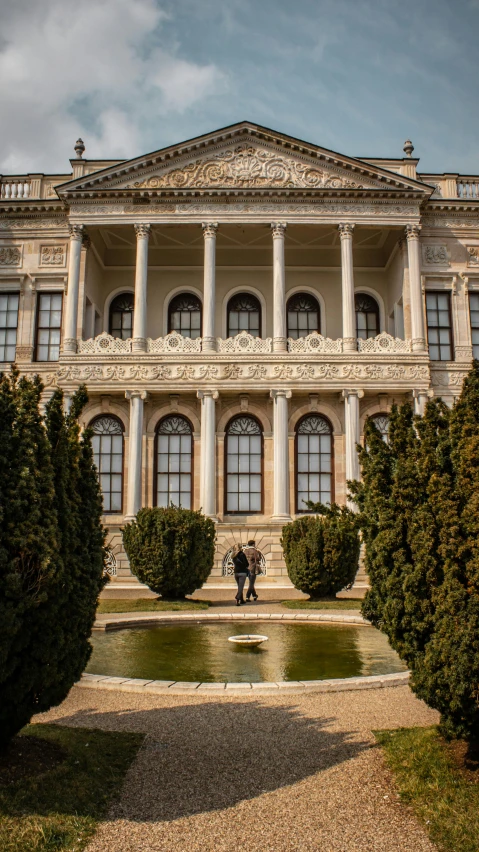 two people stand in front of an ornate building