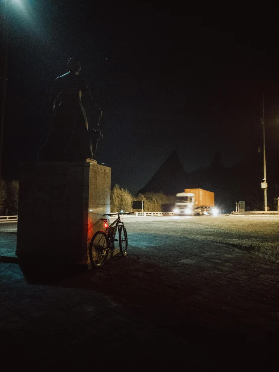 a bicycle next to a post on a dark street