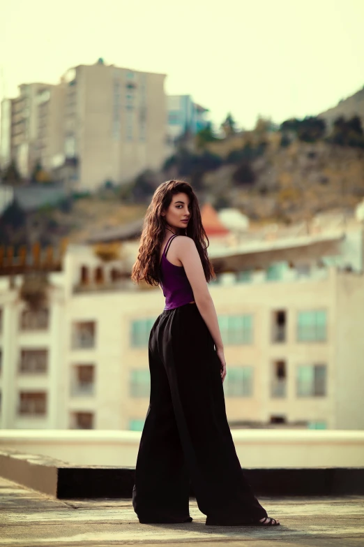 a woman is posing in a purple shirt