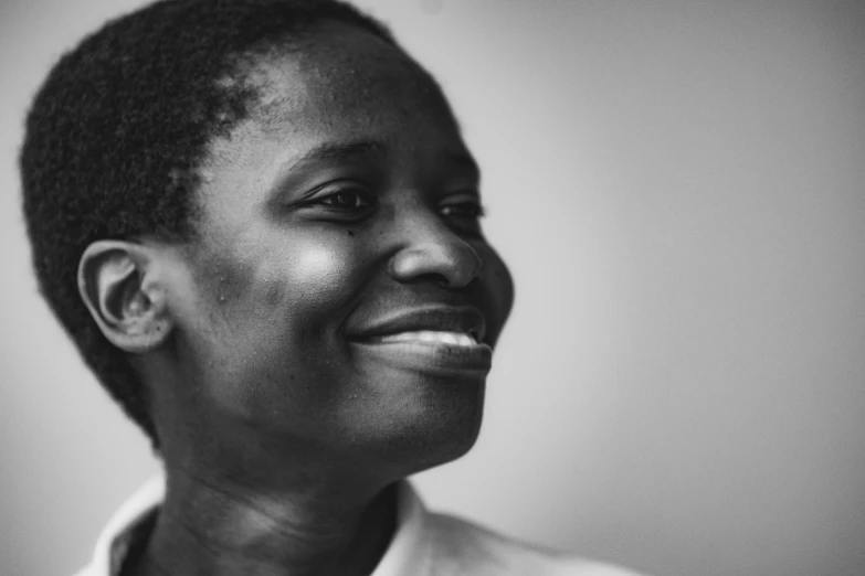 a woman smiling in black and white in a room