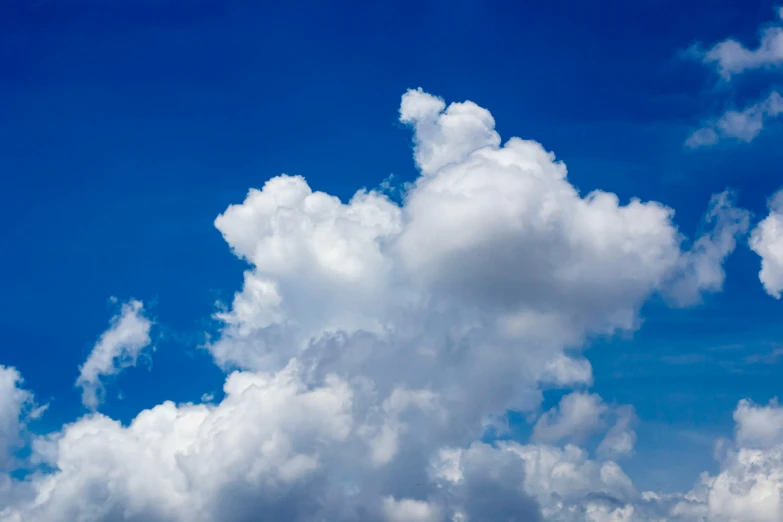 a jet flying in front of many fluffy clouds