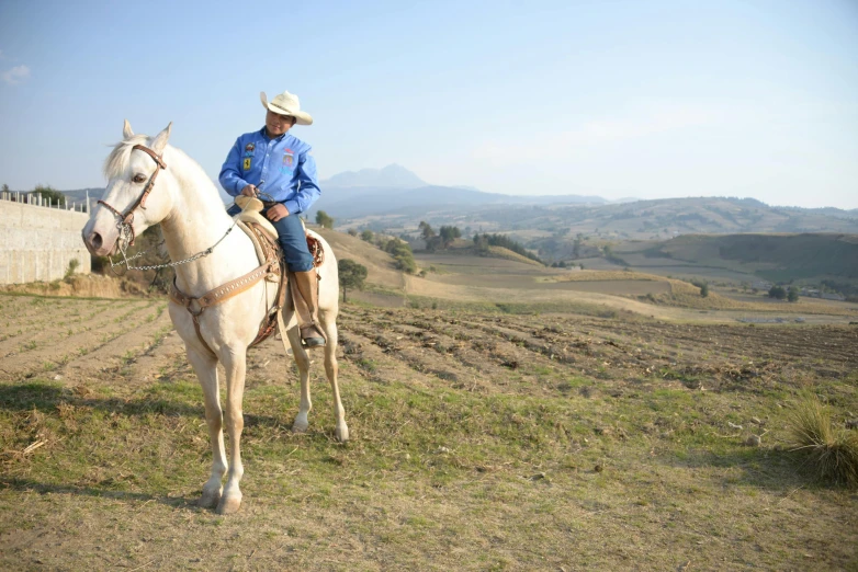 the man is riding on top of a white horse