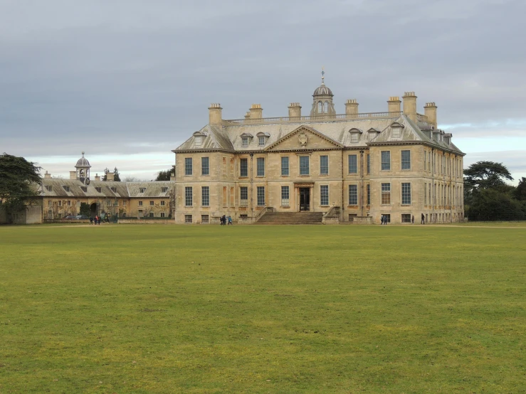 a large building sits in a grassy field