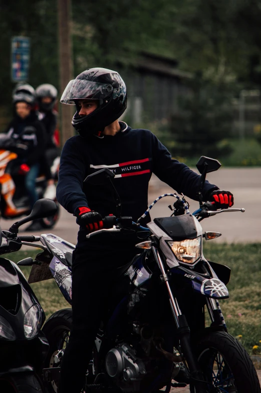 several people on motorcycles, one in a helmet and the other out