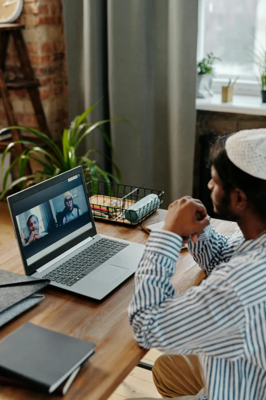 a man is sitting at the table and working on his laptop