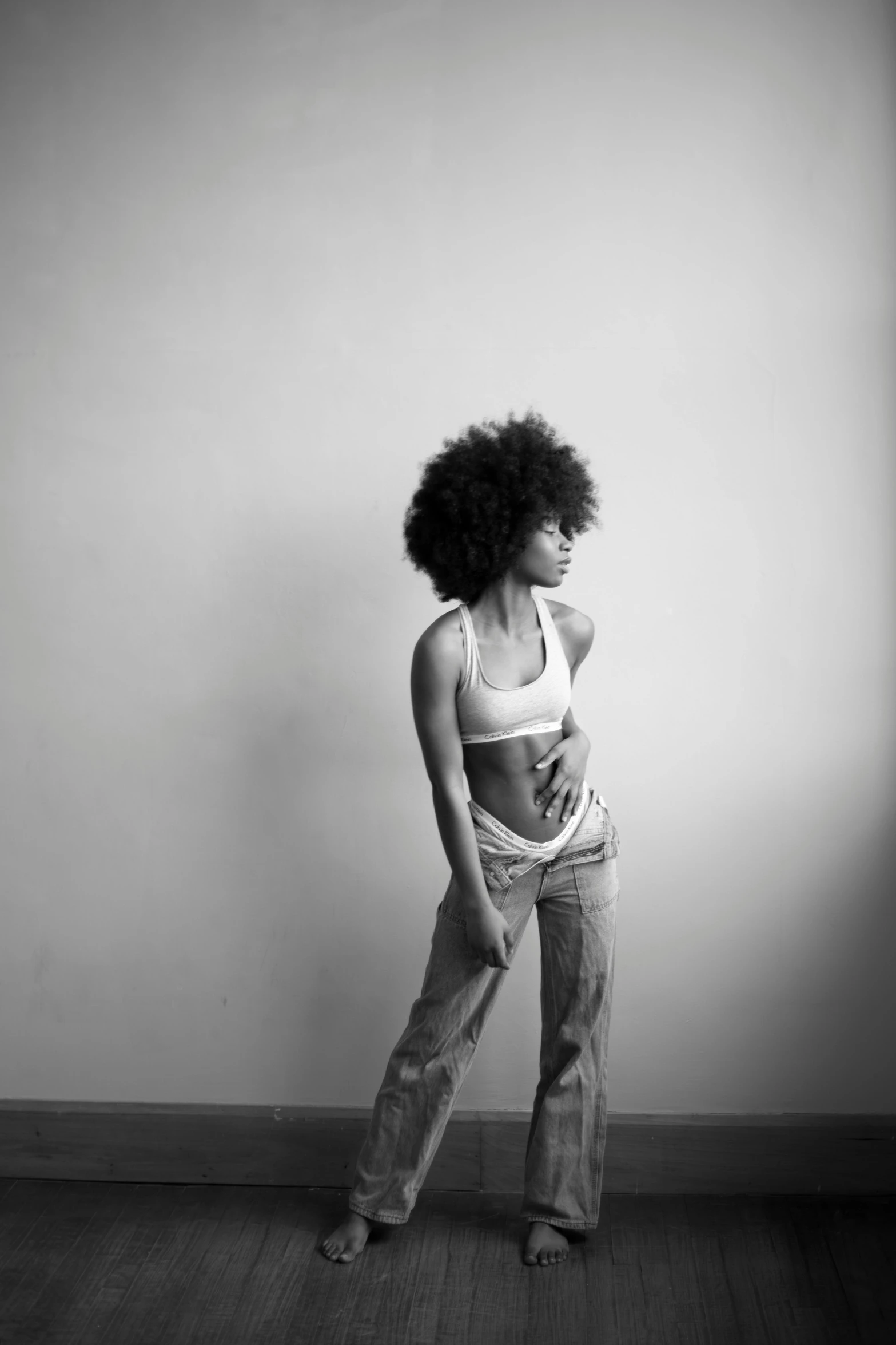 a woman is posing in her room with her back turned