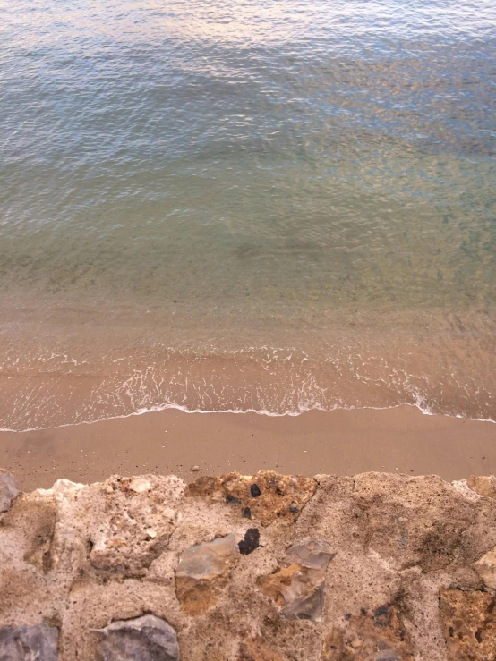 the view of a beach and water from a cliff
