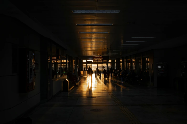 several people walking down a long corridor at night