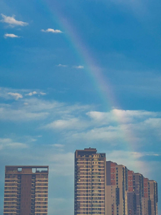 there are very few rainbows in the sky behind these buildings