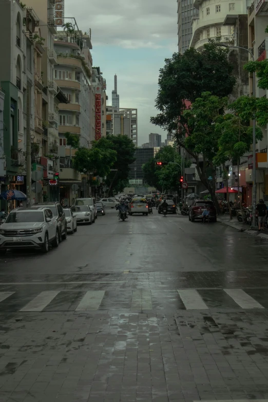 a city street in the rain with cars parked