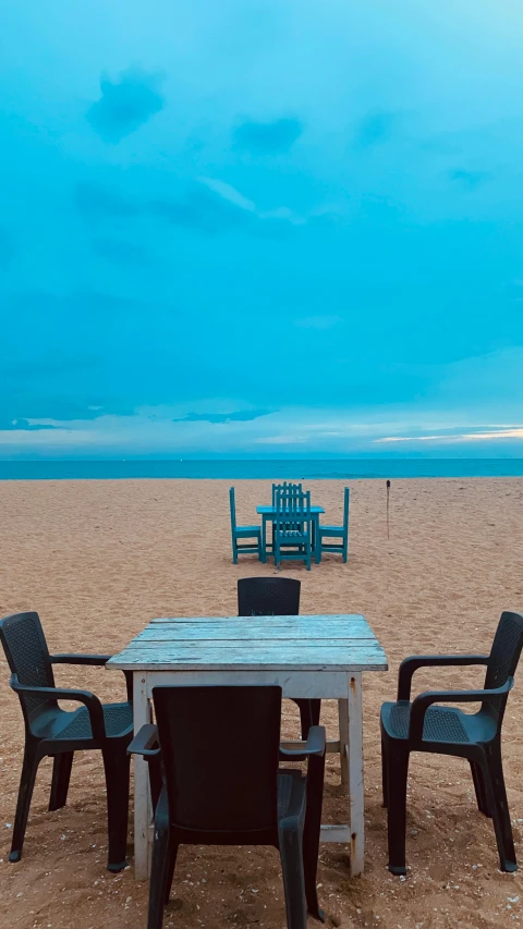 an empty table sitting on the beach during the day