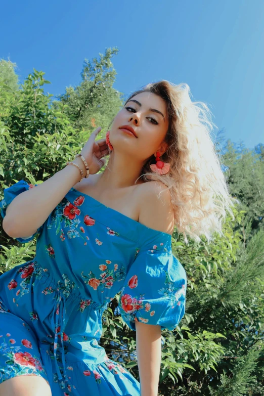 an attractive woman sitting on a bench, with her fingers in her hair