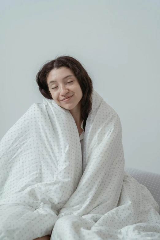 a smiling young lady wrapped in a blanket