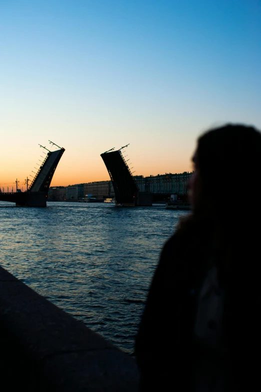 a woman standing on a bridge with an arch opening in the background